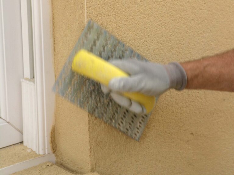 Construction worker using tool to smooth our render finish on building exterior
